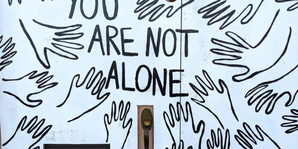 Multiple line drawing of hands with the words "you are not alone"